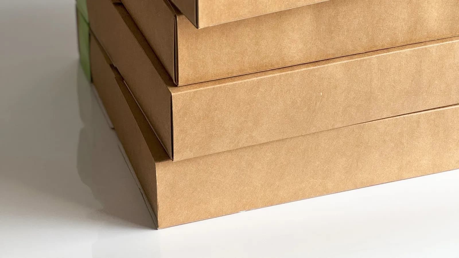 Stacked brown cardboard boxes on a white background — representing sustainable packaging
