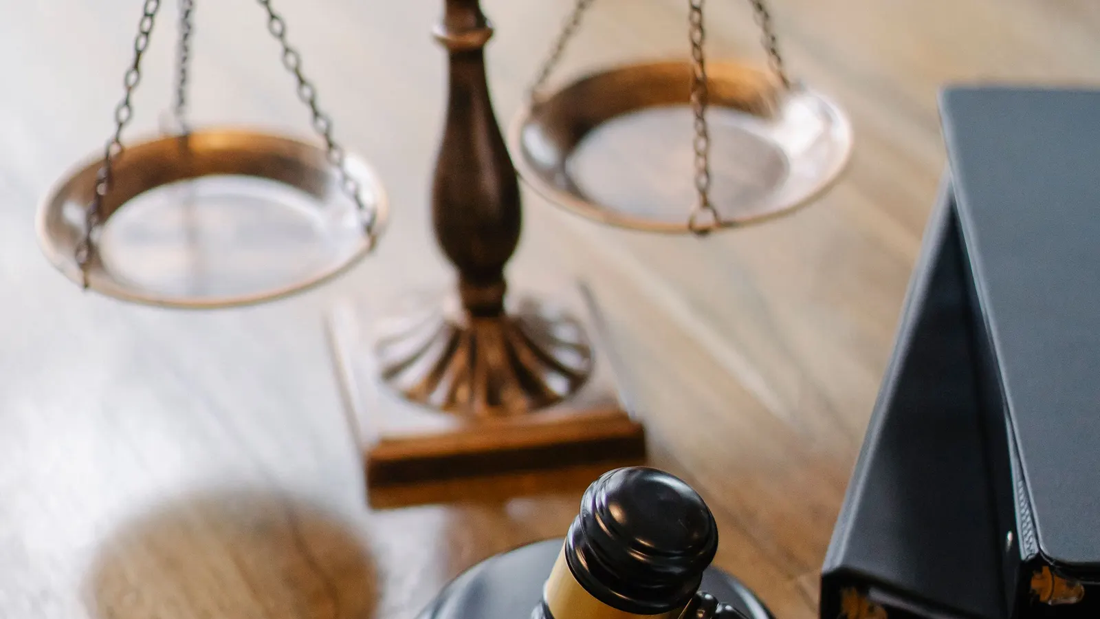 Justitia-Waage und Richterhammer auf einem Holztisch neben Aktenordnern — Symbolbild für die Pflichten von KI-Anbietern nach der KI-Verordnung